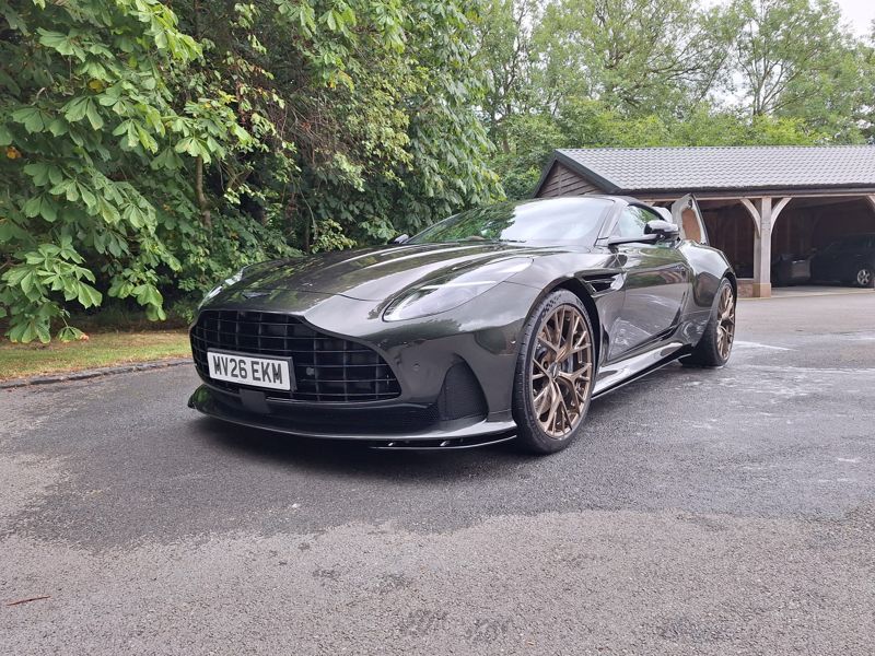 A green Aston Martin DB12, freshly valeted on a driveway